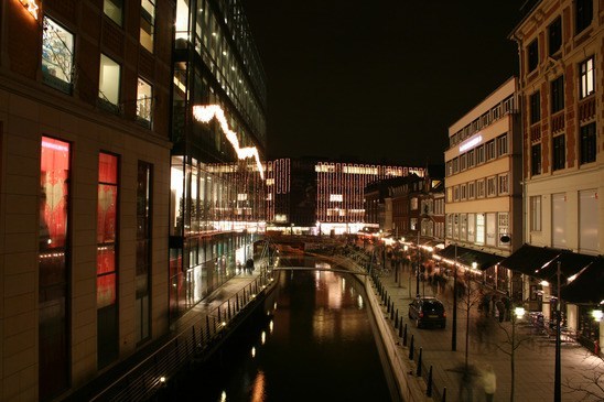 et billede af åen i aarhus om natten med lygter